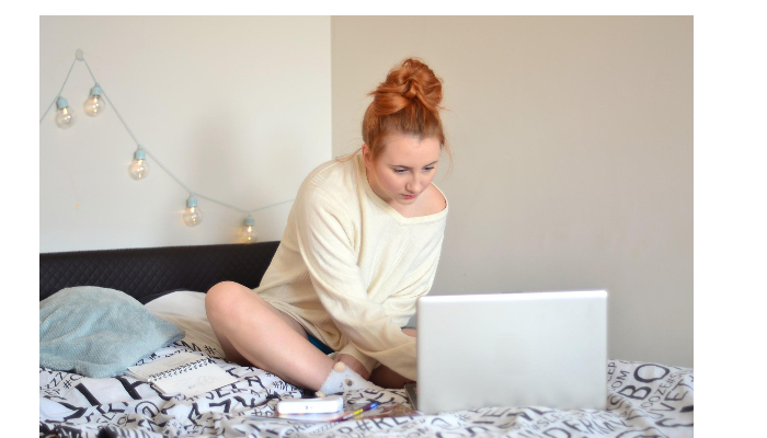 Starkey: Mädchen sitzt mit Laptop auf dem Bett