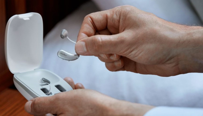 Signia: Akkuhörgeräte und Ladestation in Männerhänden