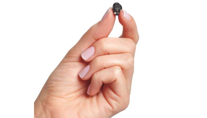 Starkey: Kleines Im-Ohr-Hörgerät zwischen den Fingern