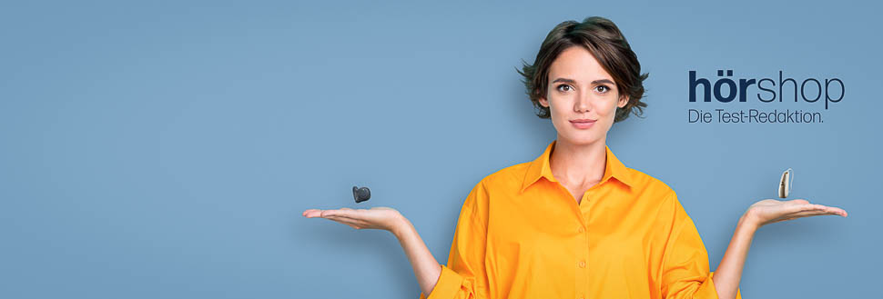 Frau im orangen Hemd balanciert Hörgeräte über ihren Händen