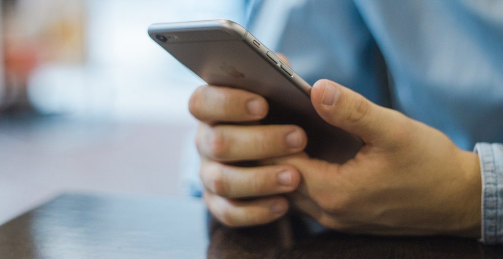 Ein Mann hält ein Smartphone in der Hand