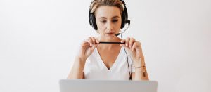 Hörgeräte-Ferneinstellung, Frau mit Kopfhörer vor einem Laptop