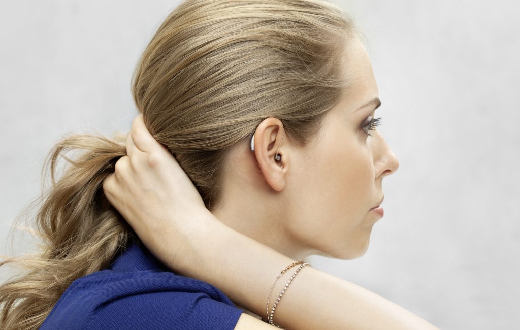 3 wichtige Vorteile von Exhörer-Hörgeräten 4 Blonde Frau von der Seite mit Exhörer-Hörgerät im Ohr