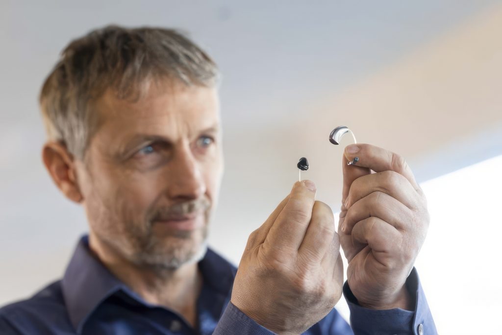 Mini Hörgeräte in der Hand eines Mannes