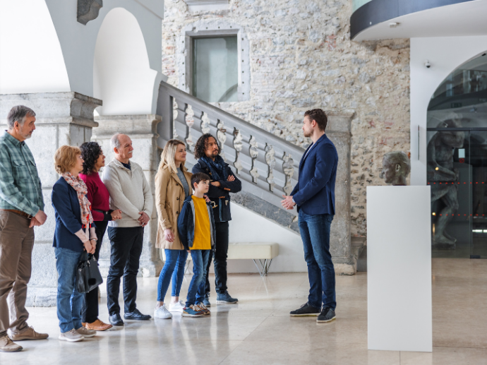 Museumsguide führt eine Gruppe. Ein Teilnehmer trägt Bluetooth-Hörgeräte.